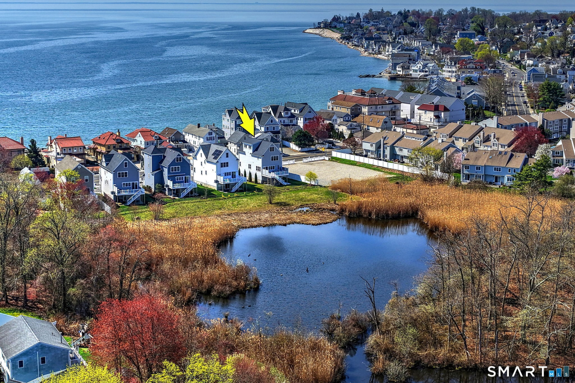 Aerial view of the home with the pond behind it