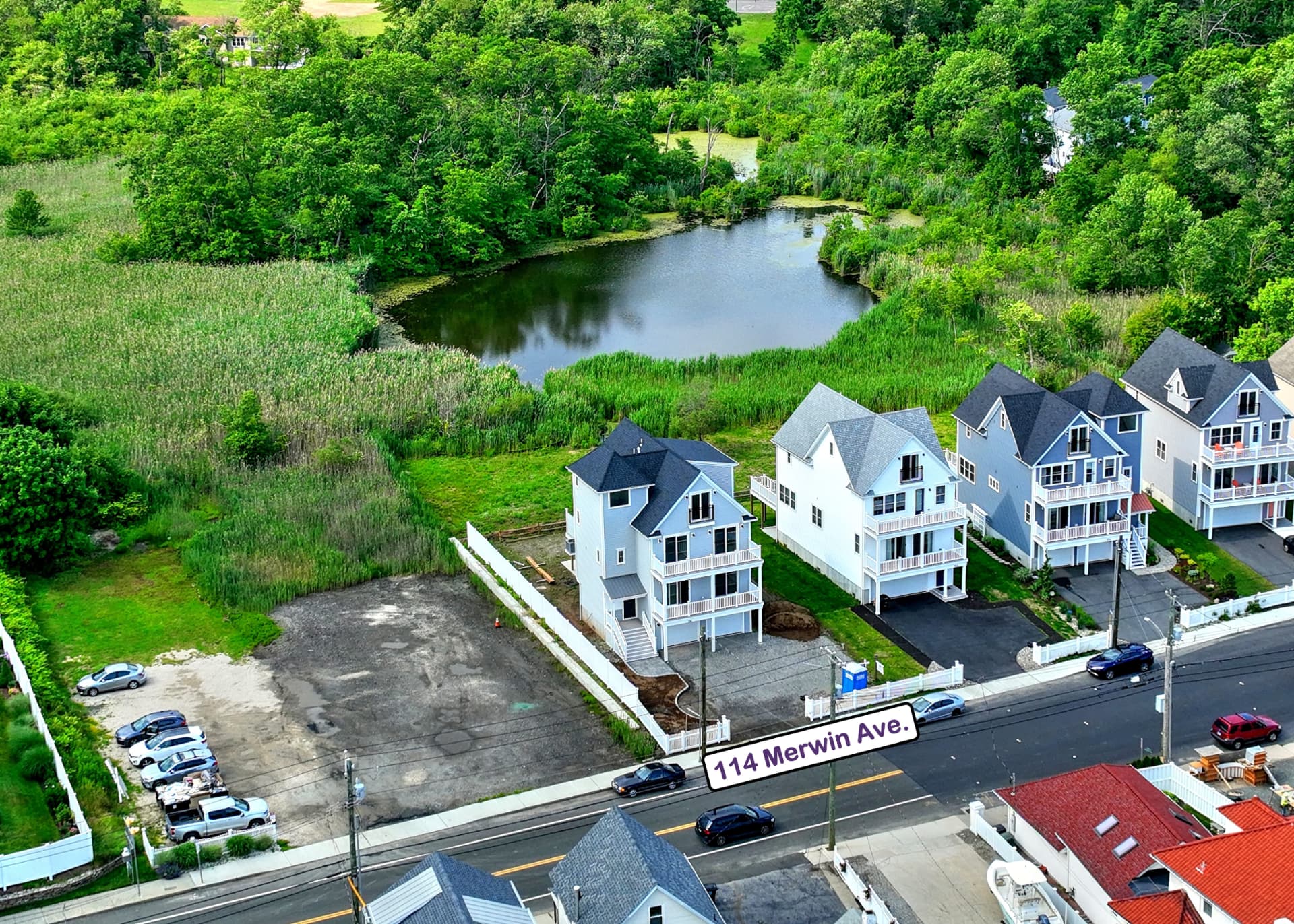 Summer aerial: the home with pond and wetlands behind
